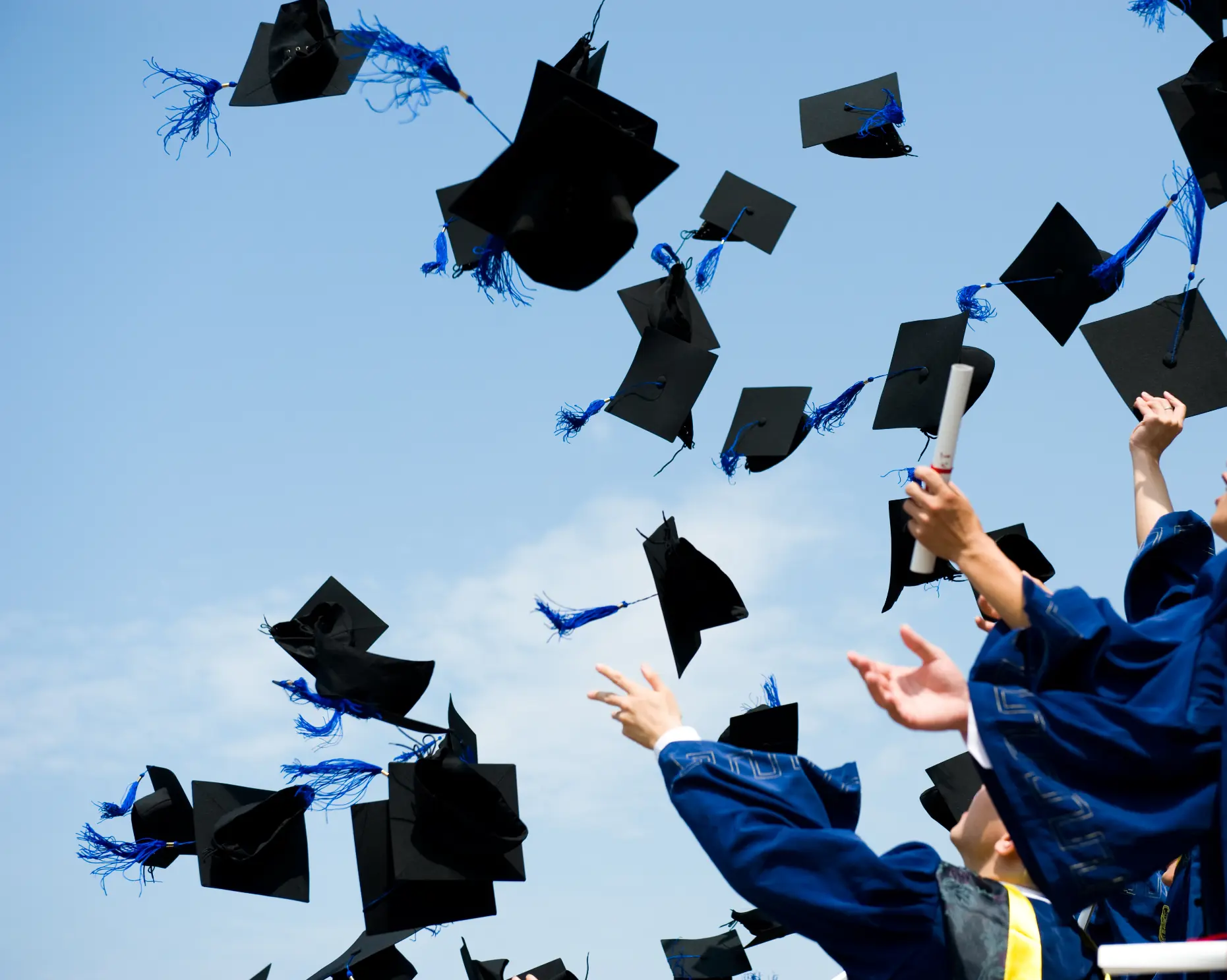 El Paso graduate smiling with diploma in hand at graduation ceremony